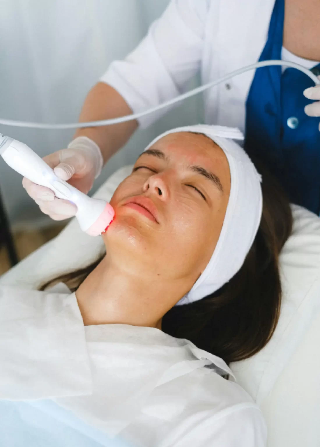Woman receiving a facial laser or LED light skin rejuvenation treatment at Emara Skin Clinic