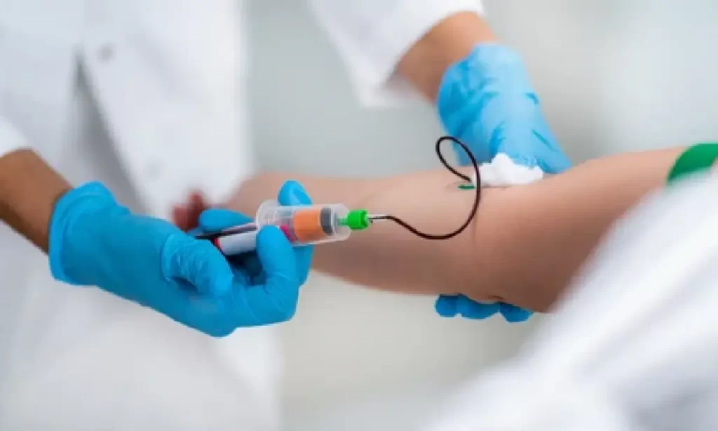 Medical professional collecting a blood sample from a patient's arm using sterile equipment at Emara Skin Clinic
